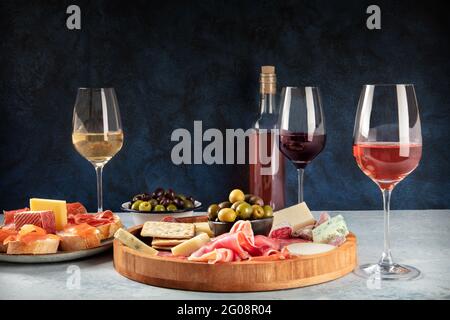 Tafel mit Wein, Wurstwaren und Käse mit Platz für Text. Schinken aus parmaschinken, Blauschimmelkäse, Oliven- und Lachsbrote, italienische Antipasti oder spanische Tapas Stockfoto