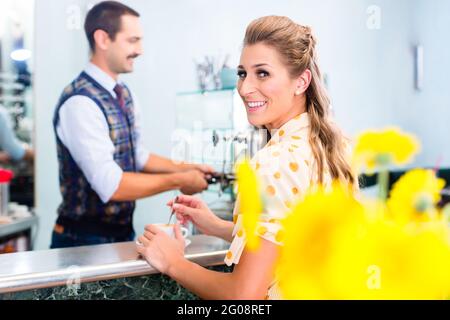 Kundin, die Espresso oder Cappuccino an der Bar im Café bestellt Stockfoto