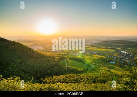 Deutschland, Sonnenuntergangsatmosphäre über endlosen Bergen und grüner Landschaft der schwäbischen alb-Naturlandschaft, Luftaufnahme von der Stadt beuren Stockfoto