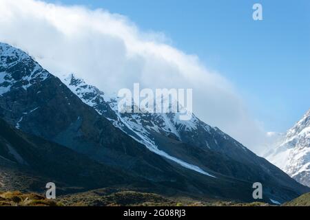 Wolken treiben über schneebedeckten Bergen im Hooker Valley, Mt Cook National Park, Südinsel Neuseelands Stockfoto