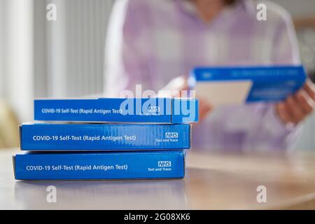 Nahaufnahme Einer Frau Zu Hause, Die Anweisungen Zur Versorgung Liest Von Covid-19 Rapid Antigen Self-Testing Kits Stockfoto