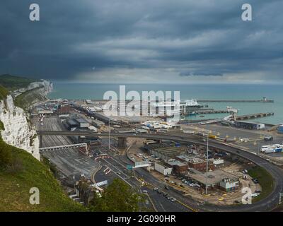 Das verschlungene Geflecht der Hafenanlage Wellington Dock mit den berühmten weißen Kreidefelsen, dem Ärmelkanal und einem dramatischen Himmel dahinter. Stockfoto