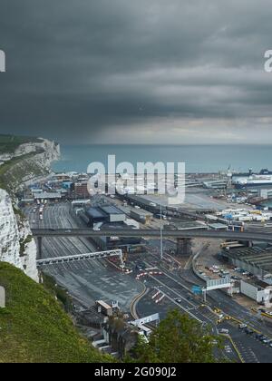 Das verschlungene Geflecht der Hafenanlage Wellington Dock mit den berühmten weißen Kreidefelsen, dem Ärmelkanal und einem dramatischen Himmel dahinter. Stockfoto