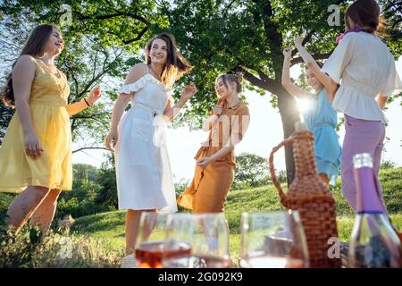 Ideen Für Sommerparty. Sichere und festliche Möglichkeiten, kleine Treffen im Freien mit Freunden zu veranstalten. Menschen kommen sicher zusammen. Junge Frauen Mädchen Freunde reden Stockfoto