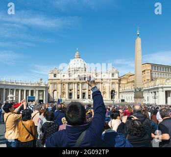 Rom, Italien. Petersdom auf einem überfüllten Petersplatz. Das historische Zentrum von Rom ist ein UNESCO-Weltkulturerbe. Stockfoto