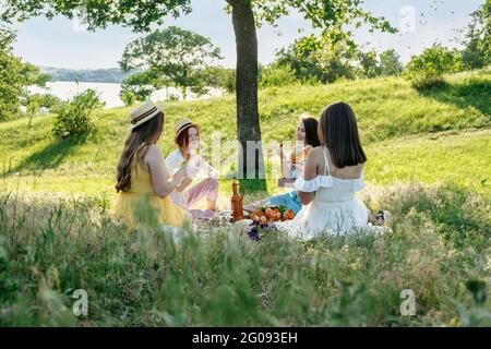 Ideen Für Sommerparty. Sichere und festliche Möglichkeiten, kleine Treffen im Freien mit Freunden zu veranstalten. Menschen kommen sicher zusammen. Junge Frauen Mädchen Freunde reden Stockfoto