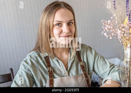 Ein Seifenhersteller legt frisch zubereitete handgemachte Seife und Körperpflegekosmetik aus und verpackt sie. Der Prozess der Zusammenstellung von Aufträgen. Spa im Haus. Kleine Busine Stockfoto