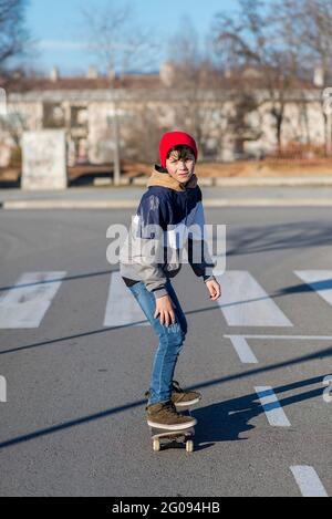 Teenager Skateboarder Junge mit einem Skateboard auf Asphalt Spielplatz macht Tricks. Jugend Generation Freizeit verbringen Konzept Bild. Stockfoto