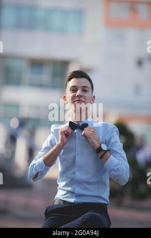 Junger, hübscher Mann in einem Hemd, lächelnd und mit dem Bogen Stockfoto