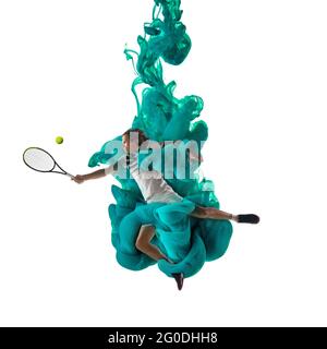 Junger Mann Tennisspieler in Explosion von farbigen neongrünen Rauch Flüssigkeit auf weißem Hintergrund isoliert. Levitation Stockfoto