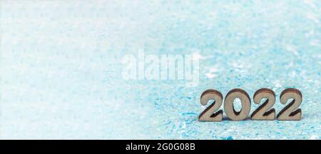 Banner 2022. Ziffern 2022 auf blauem Hintergrund. Holzziffern 2022. Stockfoto