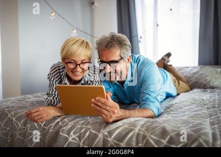 Glücklich lächelnd reifes Paar mit digitalen Tablet zu Hause Stockfoto