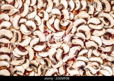 Zubereitung der Pizza margherita mit Champignons in Scheiben geschnitten für Hintergrund oder Textur, Draufsicht, Fast Food close-up. Stockfoto
