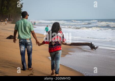 Paar, das am Sandstrand mit der Hand des anderen läuft und das natürliche Meeresbild einsaugend, wird im kochi kerala india aufgenommen und zeigt die Liebe Stockfoto