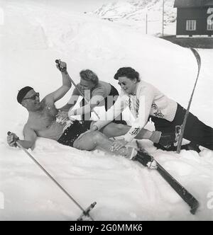 Winter in den 1940er Jahren. Der Frühling in den verschneiten schwedischen Bergen kann warm und sonnig sein, deshalb trägt er Badehosen. Er scheint auch etwas Abkühlung zu benötigen und bekommt dabei Hilfe von zwei Frauen, die ihn mit Schnee reiben. Alles hat Spaß gemacht. Schweden 1944 Ref. K9-6 Stockfoto