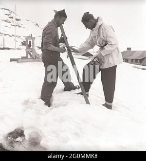 Winter in den 1940er Jahren. Zwei Männer gehen Ski und bereiten die Ski mit Skiwachs vor, um bessere Traktion auf dem Schnee zu erhalten. Sie verwenden eine Lötlampe, um das skiwachs zu schmelzen, damit es sich ordnungsgemäß unter den Skiern festigt. Schweden 1944 Ref. K9-5 Stockfoto