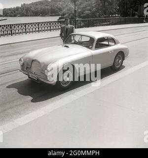 Fahren in den 1950er Jahren. Ein Mann neben seinem Auto, ein Aston Martin DB2. Dieses Modell wurde 1950 vorgestellt und in 411 Fahrzeugen produziert. Er hatte einen Sechszylindermotor, vier Gänge und einen von Frank Feeley entworfenen Chassi. Schweden 1953. ref. BL108-9 Stockfoto