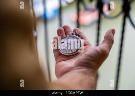 Mann, der eine Taschenuhr in der rechten Hand hält Stockfoto