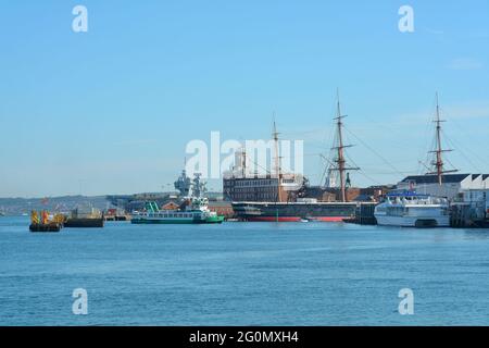 Mischung aus modernen und historischen Schiffen im Hafen von Portsmouth. Gosport und Wightlink Fähren vor der HMS Warrior, modernes Kriegsschiff in der Ferne. Stockfoto