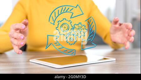 Digitales Tablet mit einem dynamischen Geschäftskonzept zwischen den Händen einer Frau im Hintergrund Stockfoto
