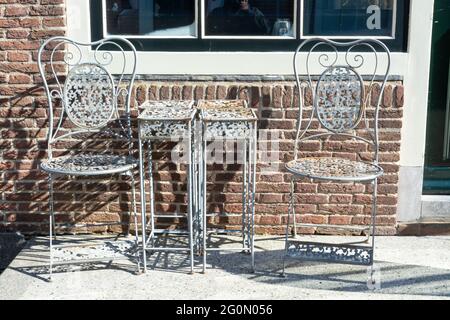 Vintage-Bistrotisch und -Stühle aus Metall im Café im Freien, zum Frühstück, Mittag- und Abendessen auf der Terrasse Stockfoto