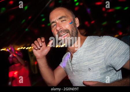 Menschen, die bei einem Familienfest in einem Zelt für eine Disco tanzen. Stockfoto