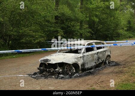 Ausgebrannte gestohlene Autos auf dem Eymore Wood Parkplatz in der Nähe von Bewdley, Worcestershire, England, Großbritannien. Stockfoto