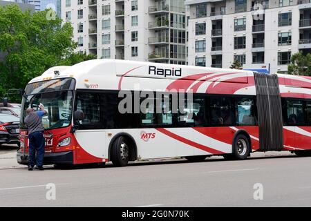 Ein Busfahrer des Rapid MTS (Metropolitan Transit System), der seine Windschutzscheibe in der Innenstadt von San Diego, Kalifornien, reinigt. Stockfoto