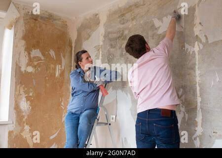 Paar diskutieren neues Design in unvollendetem Wohnzimmer während der Renovierung zu Hause Stockfoto