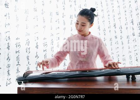 Die junge Frau spielt die Guzheng Stockfoto