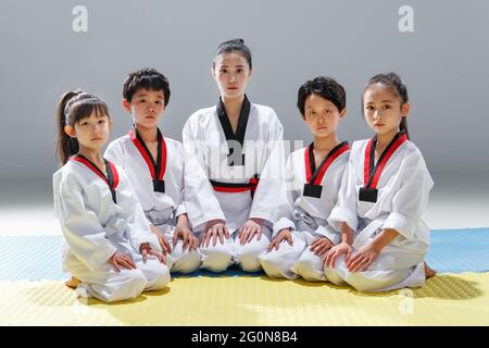 Junge Trainer lehren Schüler lernen tae kwon tun Stockfoto