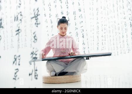 Die junge Frau spielt die Guzheng Stockfoto
