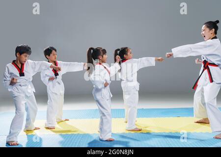 Junge Trainer lehren Schüler lernen tae kwon tun Stockfoto