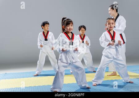 Junge Trainer lehren Schüler lernen tae kwon tun Stockfoto