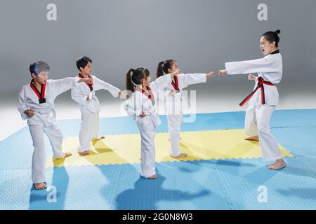 Junge Trainer lehren Schüler lernen tae kwon tun Stockfoto