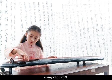 Das chinesische Zithermädchen spielen Stockfoto