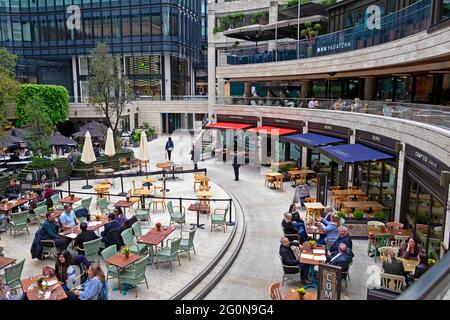 Menschen, die im Comptoir Libanais im Broadgate Circle in City of London, England, UK, SITZEN und trinken, essen im Freien an Tischen. KATHY DEWITT Stockfoto