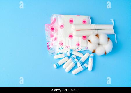 Weibliche Pads und Tampons auf blauem Papierhintergrund Stockfoto