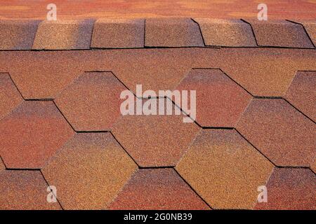 Dachstruktur des Gebäudes mit weichen Bitumen Schindeln Steinstauben Fliesen für Wasserbeständigkeit Schutzbeschichtung orange braun Nahaufnahme bedeckt, niemand. Stockfoto