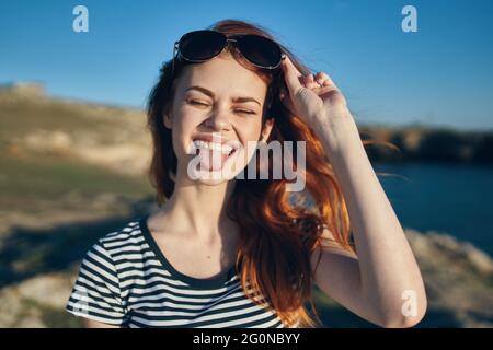 Fröhliche Frau trägt Sonnenbrillen Berge im Freien in der Nähe des Meeres Stockfoto