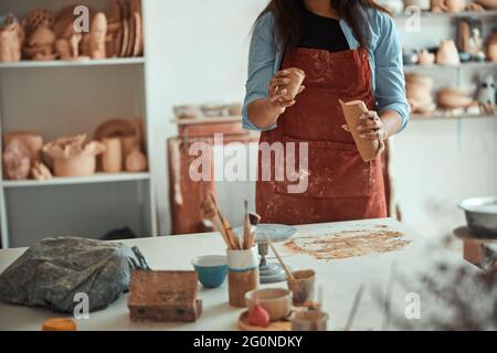 Keramikerin in Schürze, die in einem Töpferstudio arbeitet Stockfoto