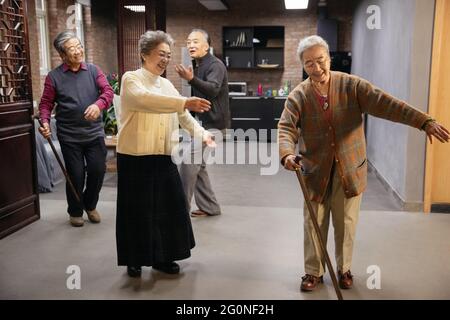Glückliche alte Menschen treffen sich zum Singen und Tanzen Stockfoto