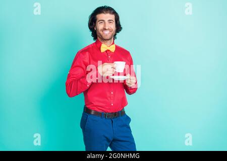 Foto von jungen gut aussehenden schönen arabischen Mann trinken Kaffee Tee genießen Freizeit isoliert auf blauem Hintergrund Stockfoto