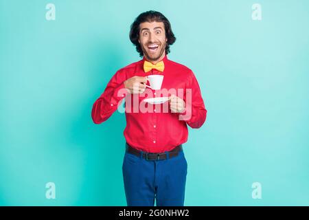 Foto von jungen funky lustig lächelnd aufgeregt Gentleman Tee trinken Pause entspannen isoliert auf blauem Hintergrund Stockfoto