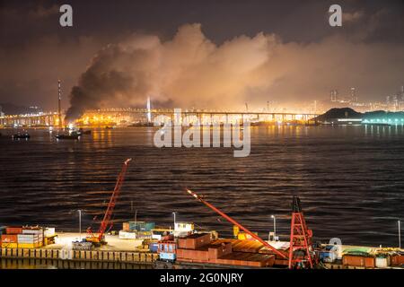 Hongkong, China 03. Juni 2021. Ein 100 Meter langes Frachtschiff, das 2,000 Tonnen Metallwaren befördert, brannte. Feuerboote und Marine-Polizeiboote eilten zum Tatort, um das Feuer zu löschen, zwei Feuerbootmonitore und zwei Jets wurden später in der Nacht eingesetzt. Bei dem Vorfall wurden keine Verletzungen gemeldet, aber Bewohner in der Nähe wurden von dem Rauch betroffen. Kredit: SOPA Images Limited/Alamy Live Nachrichten Stockfoto