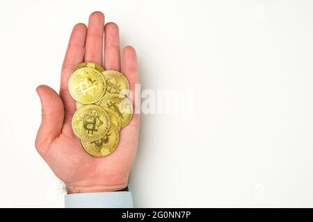 Gold Bitcoin Münzen in mans Hand. Zahlungskonzept für Kryptowährungen. Stockfoto