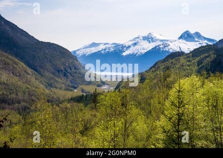 Malerische Aussicht auf den Tongass National Forest mit dem Hafen von Skagway und schneebedeckten Bergen im Hintergrund in Skagway, Alaska Stockfoto