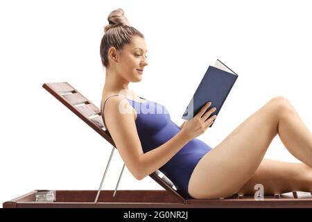 Blonde Frau liest ein Buch und entspannt sich auf einer Sonnenliege isoliert auf weißem Hintergrund Stockfoto