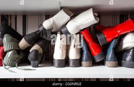 Sammlung von alten verschiedenen Schuhen in Schuhregal für die Lagerung, chaotisch und Bedürfnisse zu organisieren, Kleiderschrank mit Regalen im Haus Innenarchitektur Stockfoto