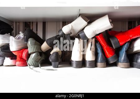 Sammlung von alten verschiedenen Schuhen in Schuhregal für die Lagerung, chaotisch und Bedürfnisse zu organisieren, Kleiderschrank mit Regalen im Haus Innenarchitektur Stockfoto